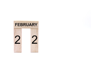 February 22 displayed wooden letter blocks on white background with space for print. Concept for calendar, reminder, date. 