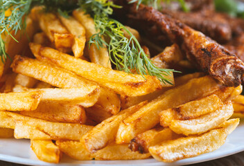 roasted chicken and french fries on a wooden table