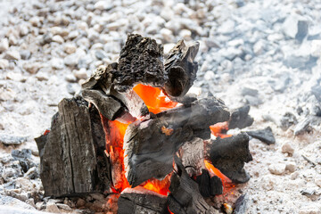 Close-up of burning coal in the fireplace. Burned charcoal in the grill.