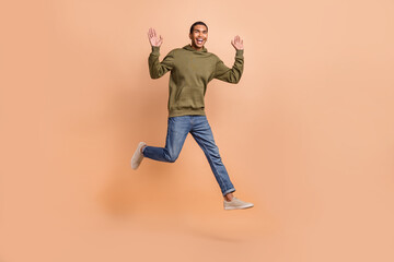 Full length photo of cheerful carefree man wear stylish clothes hurrying store discounts empty space isolated on beige color background