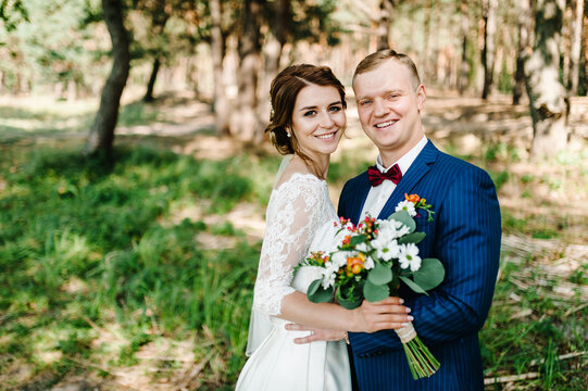 Happy young bride and groom on their wedding day. Wedding couple - new family! Bridal wedding bouquet with flowers.