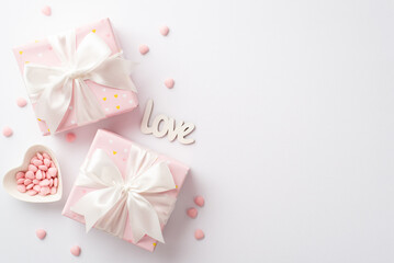 Fototapeta na wymiar Valentine's Day concept. Top view photo of pastel pink gift boxes with silk ribbon bows inscription love and heart shaped saucer with sprinkles on isolated white background with copyspace