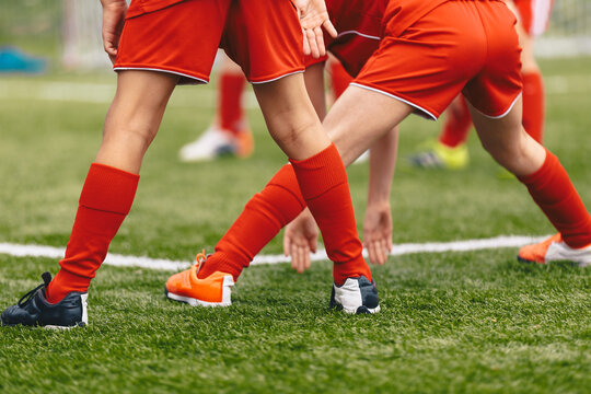 Stretching session for young football players. Youth soccer players warming up before the match. School kids at outdoor practice training unit.