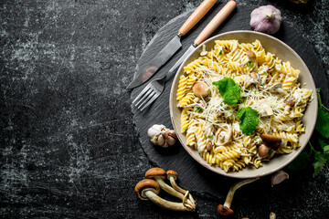 Fusilli pasta in a bowl of mushrooms and garlic.