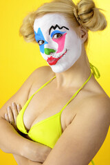 Ugly horror clown in bikini celebrates halloween or carnival
