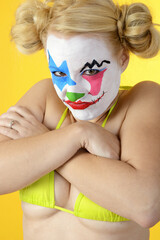 Angry looking clown celebrates halloween or carnival in bikini and is silly and funny	

