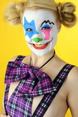 Horror clown celebrates halloween or carnival in dungarees and bow tie as a costume and is silly and funny	