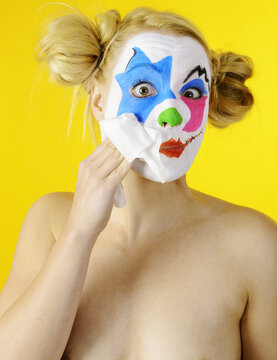 Beautiful female clown is removing making up 