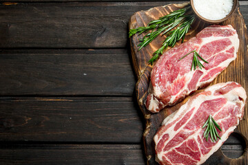 Raw pork steaks with rosemary.