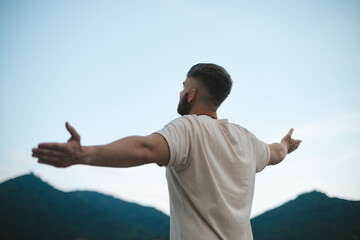 happy handsome man relax nature, young calm carefree man traveler with open raised hands enjoy mountain, one person feeling good, breath deep deeply fresh air. Freedom, travel, happiness concept