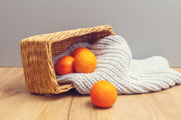 wicker basket with tangerines and knitted scarf