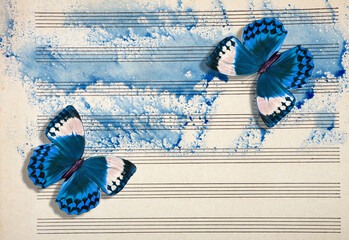 Old music sheet in blue watercolor paint and tropical morpho butterflies.  Music concept.
