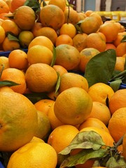 Tangerines with stems and leaves, for sale at market. Fresh tangerines. Tangerines at market. 