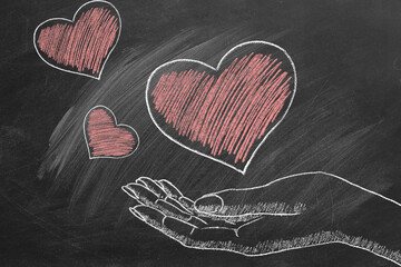 Hearts in a female hand. Chalk drawn illustration. Heart transplant and organ donation. The concept of charity, love, donate and helping hand. I Love You. Happy Valentine's day. World heart day