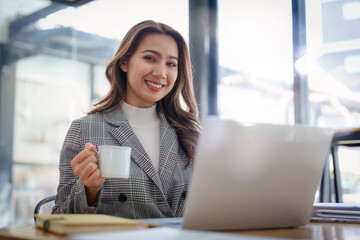Fototapeta premium Portrait of Smiling asian business woman with laptop computer in office. Woman in suit at office