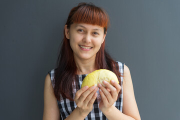 Close up A woman handle durian show the yellow durian meat to eat. The durian is a king of fruit of...