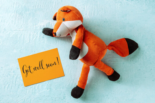 Get Well Soon greeting card with a toy fox, orange paper and blue background