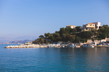 Aerial view of Kassiopi, village in northeast coast of Corfu island, Ionian Islands, Kerkyra, Greece in a summer sunny day, with marina, town, beach and castle