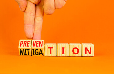 Prevention or mitigation symbol. Businessman turns cubes and changes the concept word Mitigation to...