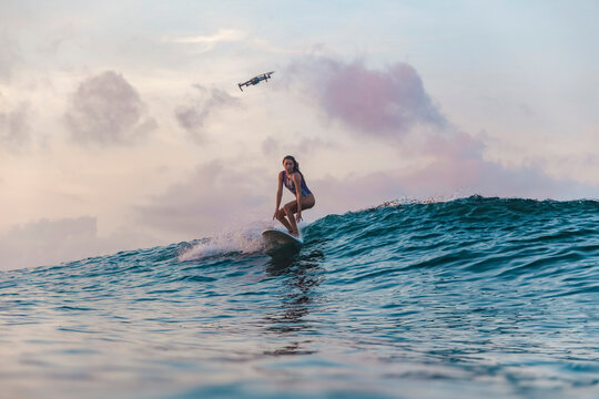 Female surfer in ocean at sunset