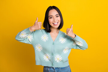 Photo of positive japanese girl wear daisy blue ornament pullover thumbs up recommend new shopping mall isolated on yellow color background