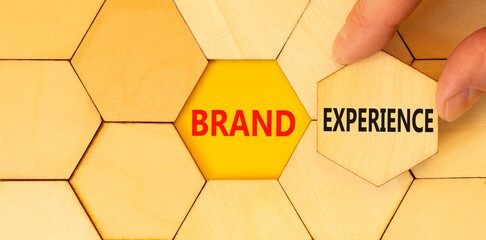 Brand experience symbol. Concept words Brand experience on wooden puzzles. Beautiful yellow table...
