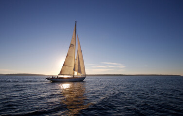 The crew of a sailing yacht takes her out for a sunset cruise off the coast of Maine.
