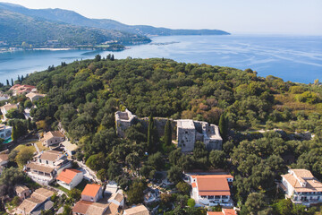 Fototapeta na wymiar Aerial drone view of Kassiopi, village in northeast coast of Corfu island, Ionian Islands, Kerkyra, Greece in a summer sunny day, with marina, town, beach and castle