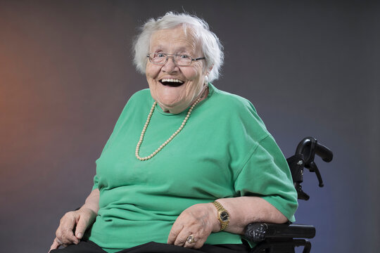 Portrait of senior woman sitting in wheelchair and laughing