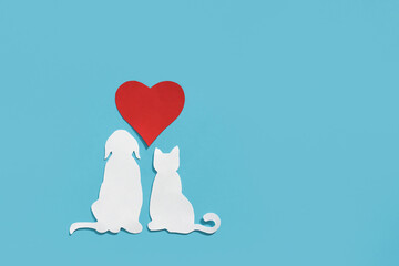 Paper silhouette of a cat, dog and red heart on a blue background. Flat lay, place for text....