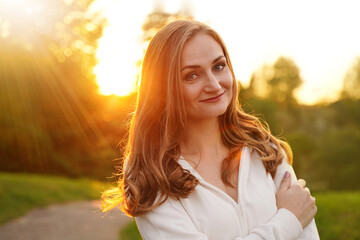 Cute blonde girl on background of sun. Ordinary happy woman enjoying life in summer. Confident...