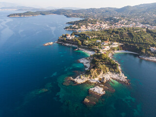 Aerial drone view of Kassiopi, village in northeast coast of Corfu island, Ionian Islands, Kerkyra, Greece in a summer sunny day, with marina, town, beach and castle