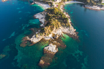Aerial drone view of Kassiopi, village in northeast coast of Corfu island, Ionian Islands, Kerkyra, Greece in a summer sunny day, with marina, town, beach and castle