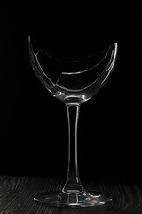 Broken glass goblet. Stands on black boards. Shot on a black background.
