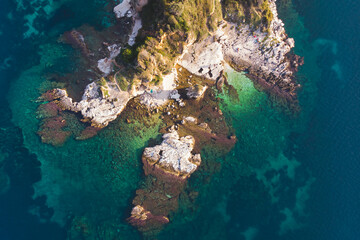 Aerial drone view of Kassiopi, village in northeast coast of Corfu island, Ionian Islands, Kerkyra, Greece in a summer sunny day, with marina, town, beach and castle