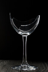 Broken glass goblet. Stands on black boards. Shot on a black background.