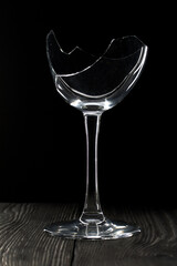 Broken glass goblet. Stands on black boards. Shot on a black background.
