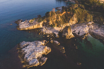 Aerial drone view of Kassiopi, village in northeast coast of Corfu island, Ionian Islands, Kerkyra, Greece in a summer sunny day, with marina, town, beach and castle