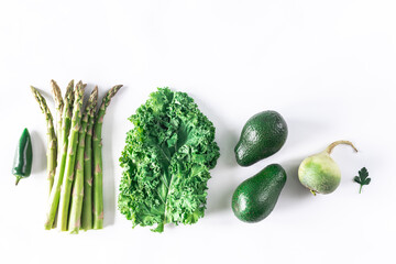 Asparagus, kale, hot pepper, avocado, radish on a white stone background. Organic healthy food.