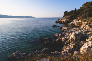 Fototapeta premium Aerial view of beach in Kassiopi village in northeast coast of Corfu island, Ionian Islands, Kerkyra, Greece in a summer sunny day