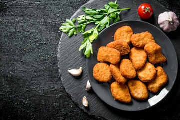 Chicken nuggets with parsley and garlic cloves.