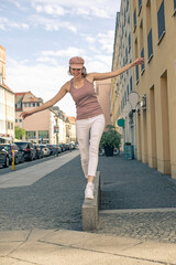 gl&uuml;ckliche junge Frau balanciert  in der Stadt