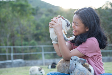 teenage girl with the rabbit. happy little girl holding cute fluffy bunny. friendship with easter...