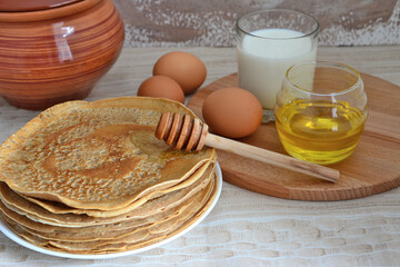 russian maslenitsa with fried blini, honey and milk isolated on beige background