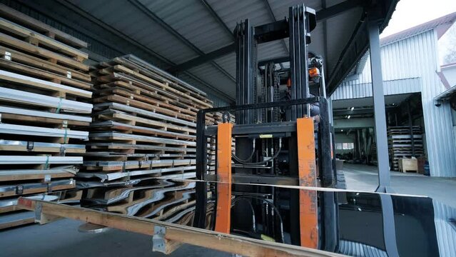 Forklift in a large industrial warehouse of stainless steel. Warehouse for stainless steel