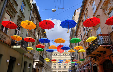 decorated with the umbrellas hanging from the wires on the narrow street of the old city