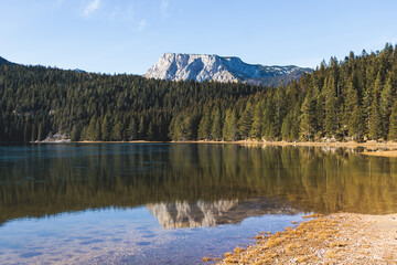 Fototapeta na wymiar Beautiful view of Black lake, Crno Jezero in Durmitor National Park, Zabljak, northern Montenegro, landscape in a sunny day with blue sky, with glacial lake, forest hiking trail and mountain peaks