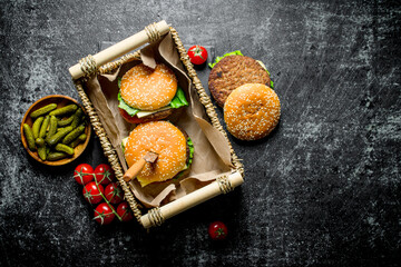 Fototapeta premium Burgers in the basket and gherkins in the bowl.