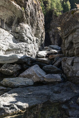 Bed of Lillaz waterfall (Cascate di Lillaz) divided by thousands of years of formation in granite alpine rocks, dried up this season with little pond. Aosta valley, Italy (vertical photo)