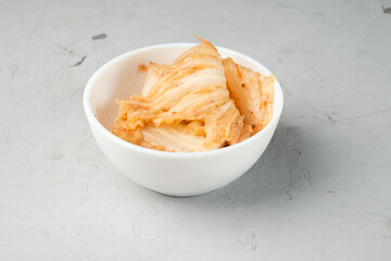 Fermented cabbage spicy Korean kimchi in a white bowl.